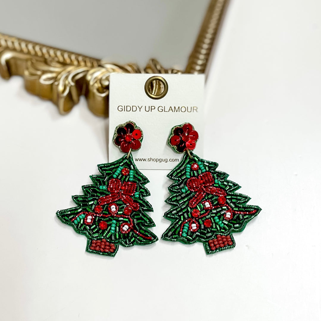 Beaded Christmas tree earrings with red bows and floral stud tops, festive holiday jewelry measuring 2.75 inches long.