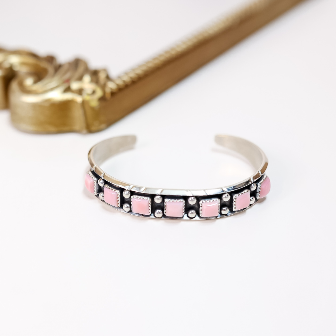 Native American handmade sterling silver cuff bracelet featuring square pink conch shell inlays and silver bead detailing, crafted by artist Presley Curley.