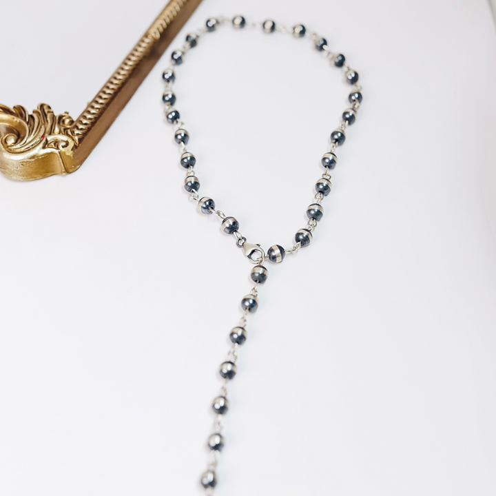 10mm sterling silver Navajo pearl chain link necklace styled as both a classic and lariat necklace on white background with gold frame accent.