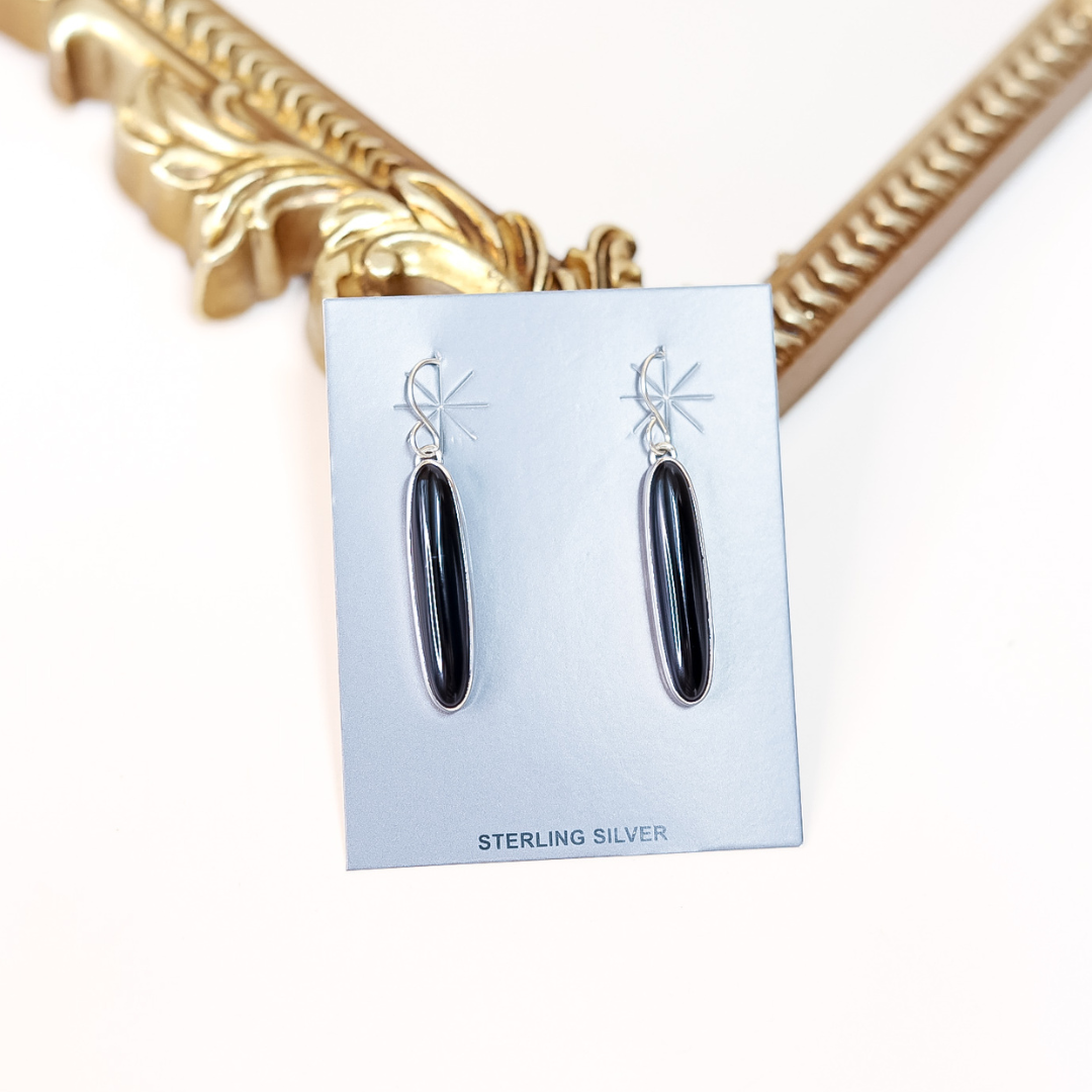 Sterling silver Navajo drop earrings with long oval black onyx stones, handmade by artist Theresa Smith.