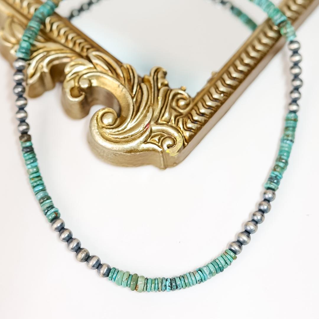 Hand-strung Red River turquoise and 6mm Navajo pearl necklace displayed on a mirror with gold frame; 16-inch length with 2-inch adjustable chain, boho western jewelry style.
