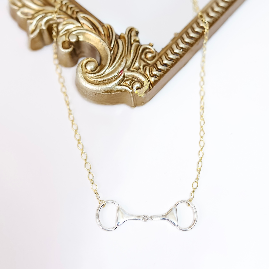 Close-up of Sterling Silver and 14K Gold plated horse bit necklace with snaffle bit pendant on adjustable chain, handmade and stamped by artist "HaDa".
