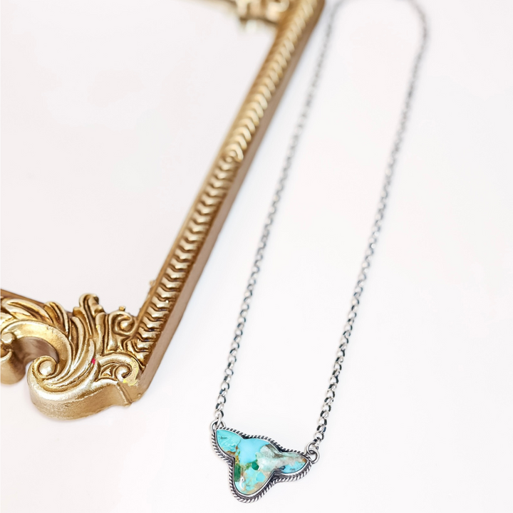 Sterling silver cow head silhouette necklace with turquoise stone, handmade by Native American artist Leroy James.