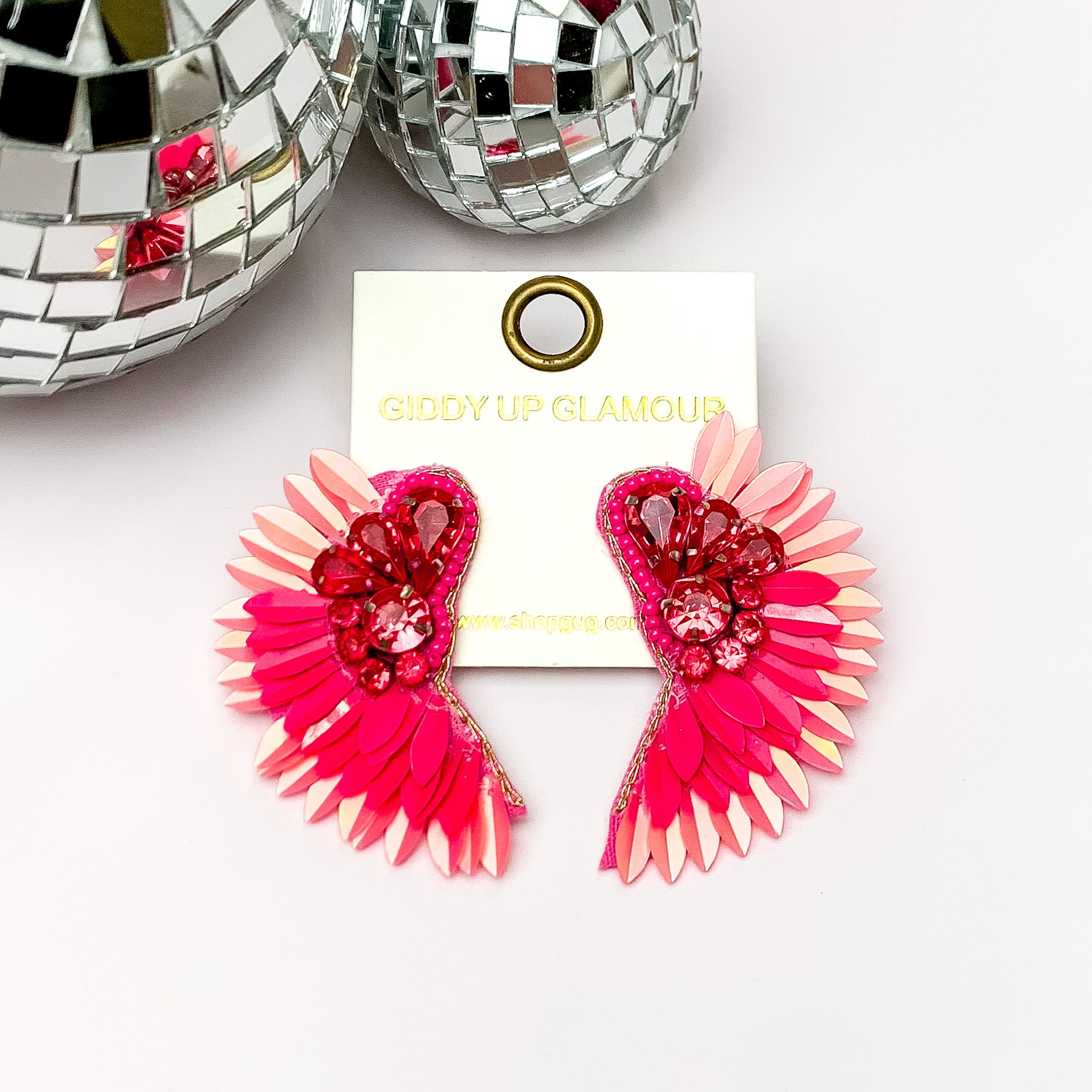 Saw An Angel Sequin Earrings with Clear Crystals in Pink. Pictured on a white background with disco balls in the top left.