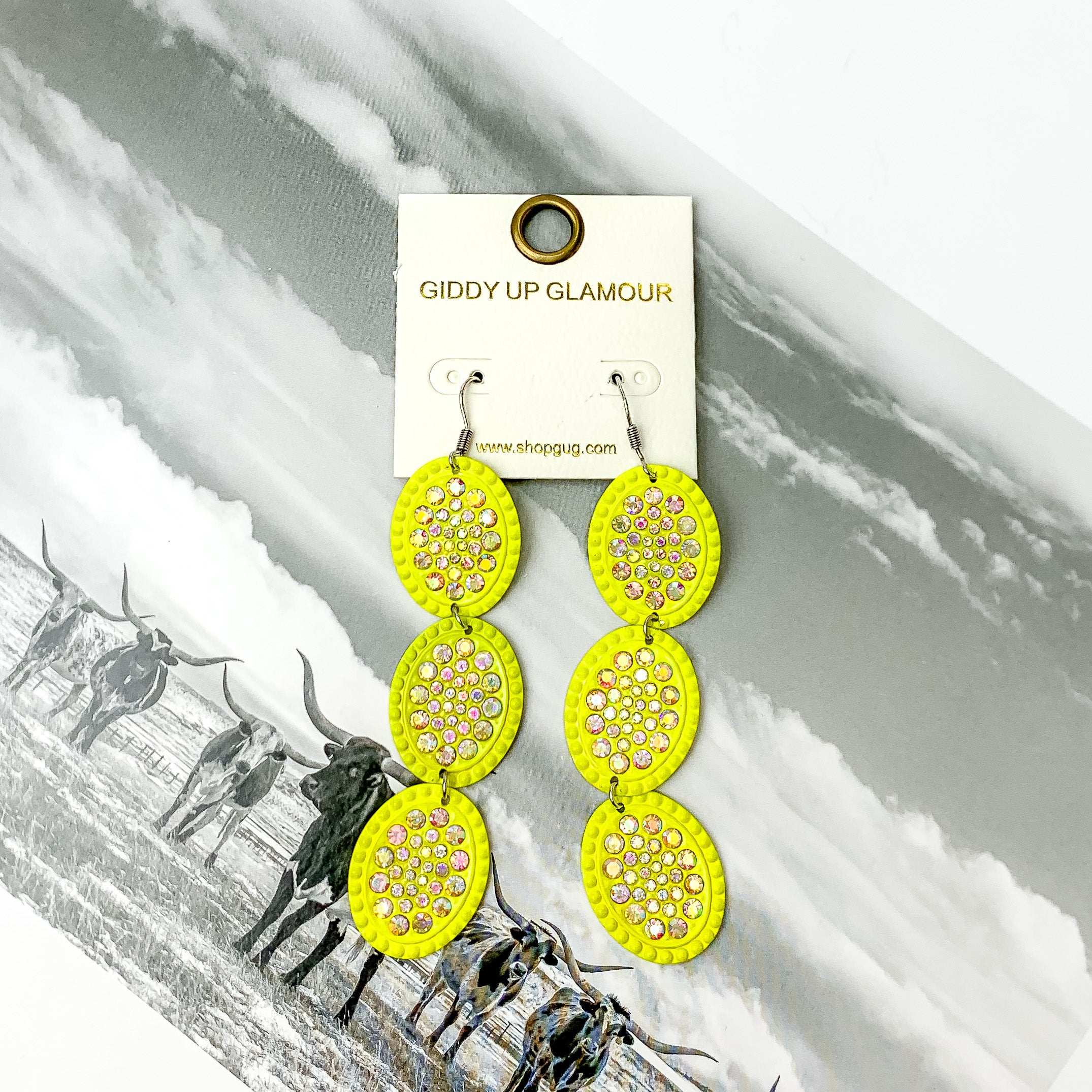 Three tier neon yellow with ab crystal oval shape dangle earrings. Pictured on a black and white western picture.