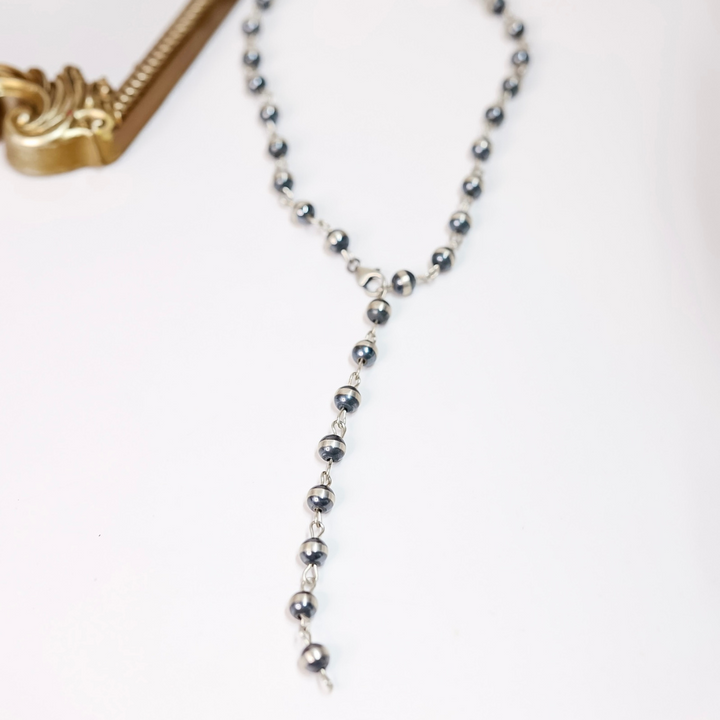 10mm sterling silver Navajo pearl chain link necklace styled as both a classic and lariat necklace on white background with gold frame accent.