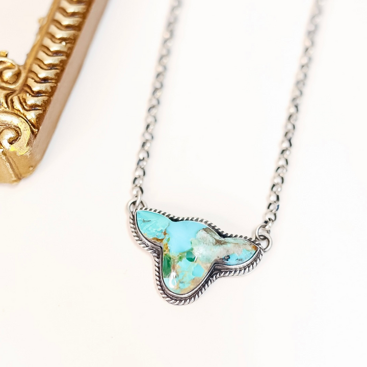 Sterling silver cow head silhouette necklace with turquoise stone, handmade by Native American artist Leroy James.