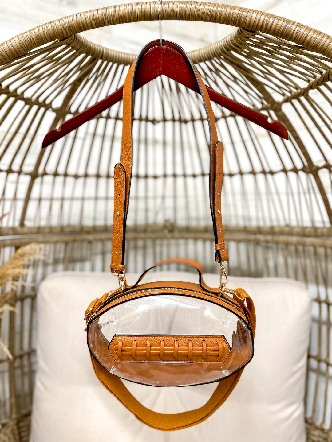 Clear football-shaped stadium bag with faux leather trim and gold hardware from Giddy Up Glamour.