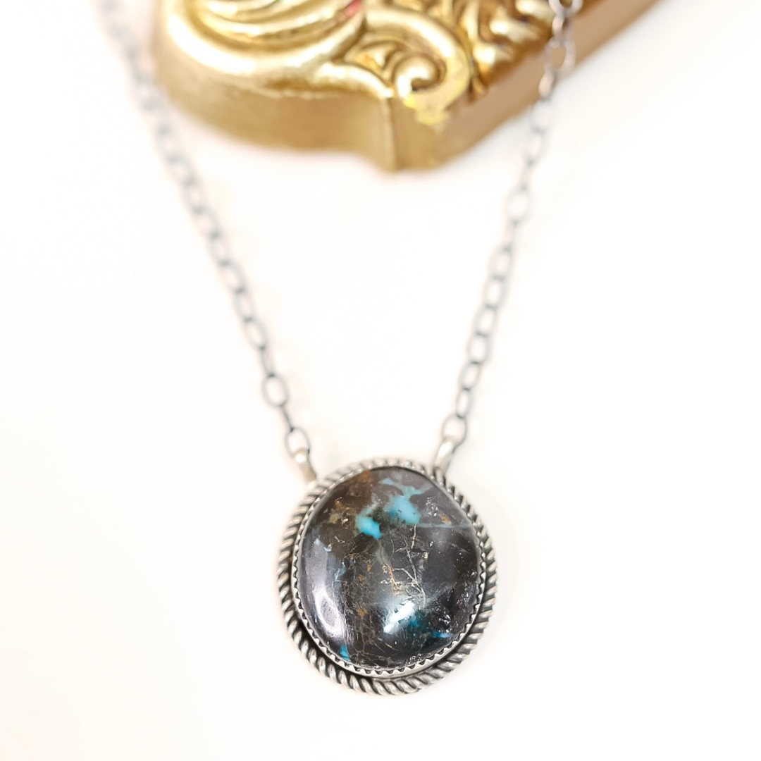 Sterling silver Blue Moon Turquoise necklace by Tia Long featuring a round natural stone pendant with black and blue marbling on silver chain.