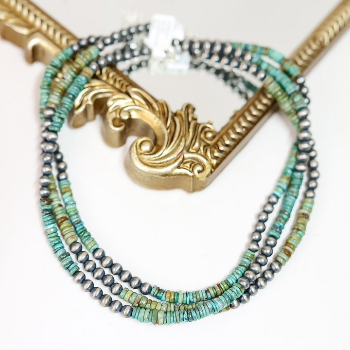 Hand-strung Red River turquoise and 6mm Navajo pearl necklace displayed on a mirror with gold frame; 16-inch length with 2-inch adjustable chain, boho western jewelry style.