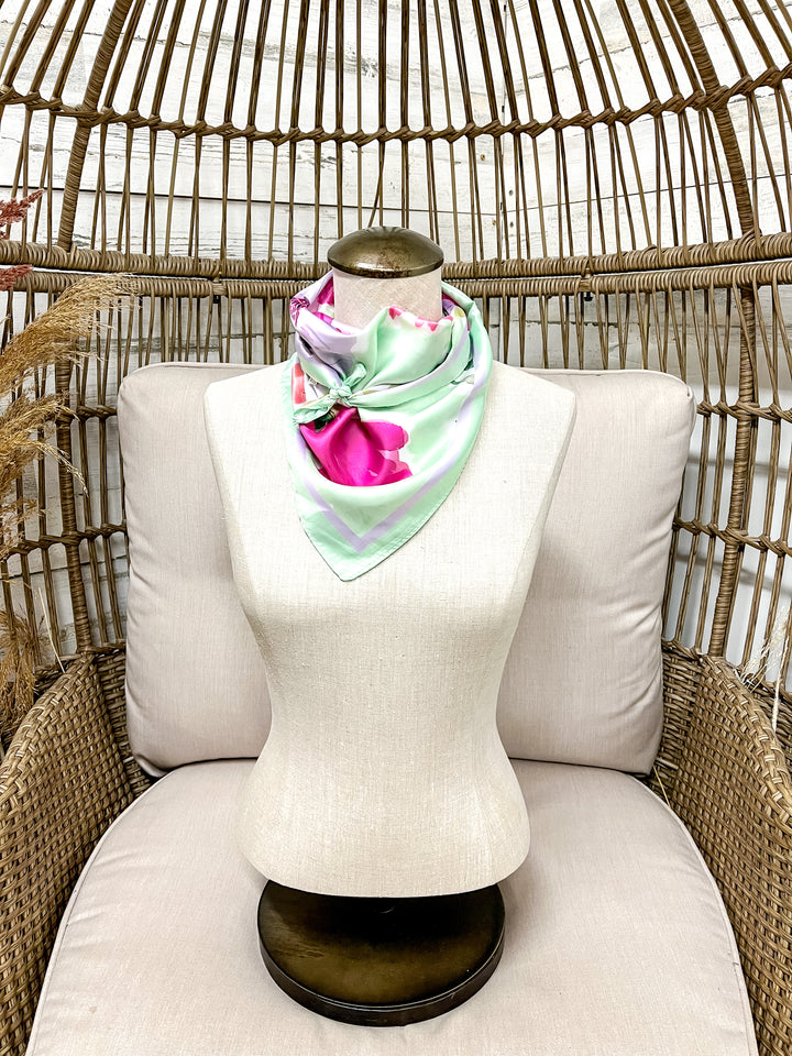 Mannequin wearing a colorful scarf with a wicker chair background