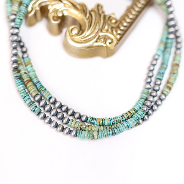 Hand-strung Red River turquoise and 6mm Navajo pearl necklace displayed on a mirror with gold frame; 16-inch length with 2-inch adjustable chain, boho western jewelry style.