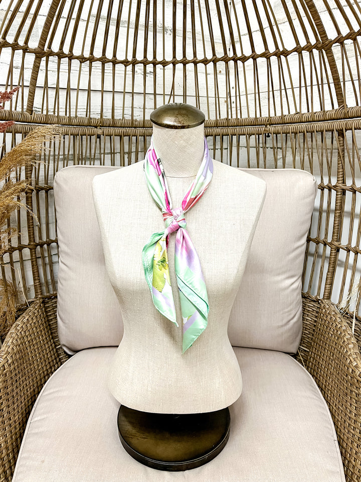 Mannequin with a colorful scarf draped over it, sitting on a wicker chair.