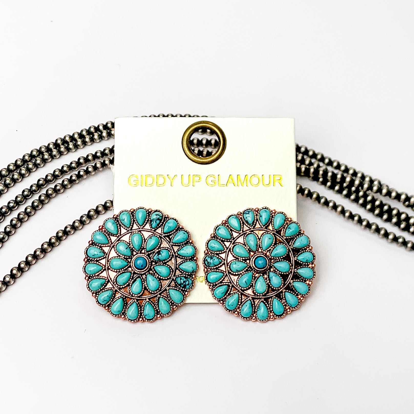 Copper Tone Circle Cluster Stud Earrings with Turquoise Stones. Pictured on a white background with beads through it.