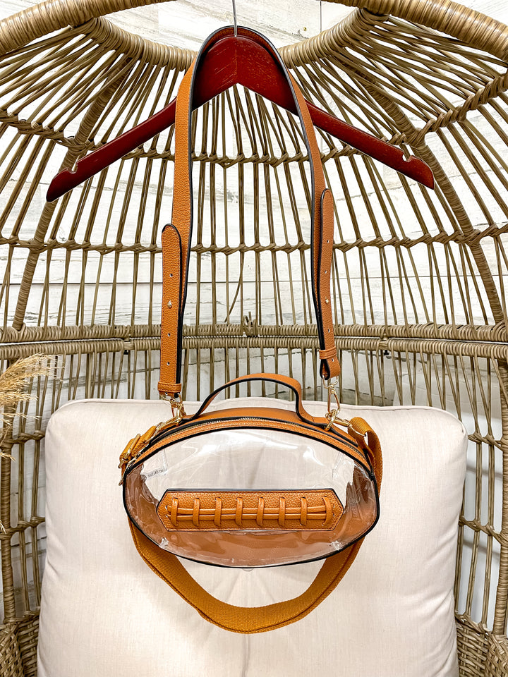 Clear football-shaped stadium bag with faux leather trim and gold hardware from Giddy Up Glamour.