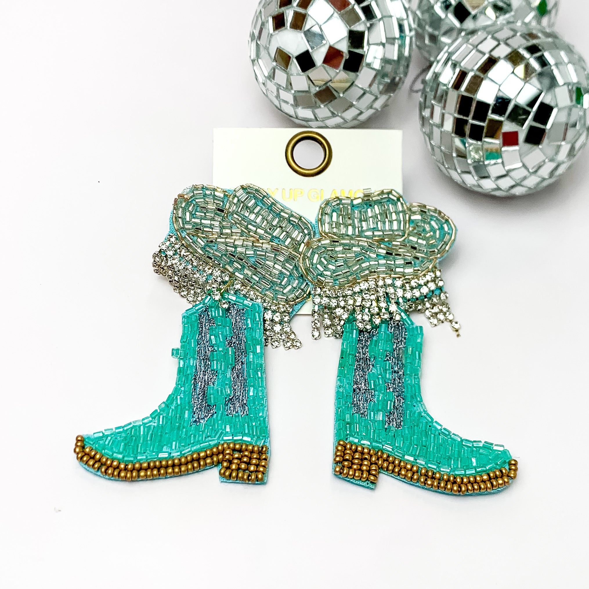 Beaded Blue Cowboy Boot Earrings with Silver Hat Studs. Pictured on a white background with disco balls in the top right corner.