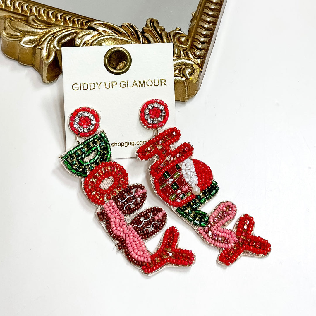 Beaded “Holly Dolly” Christmas earrings in pink, red, and green with Santa hat detail, measuring 3 inches long.