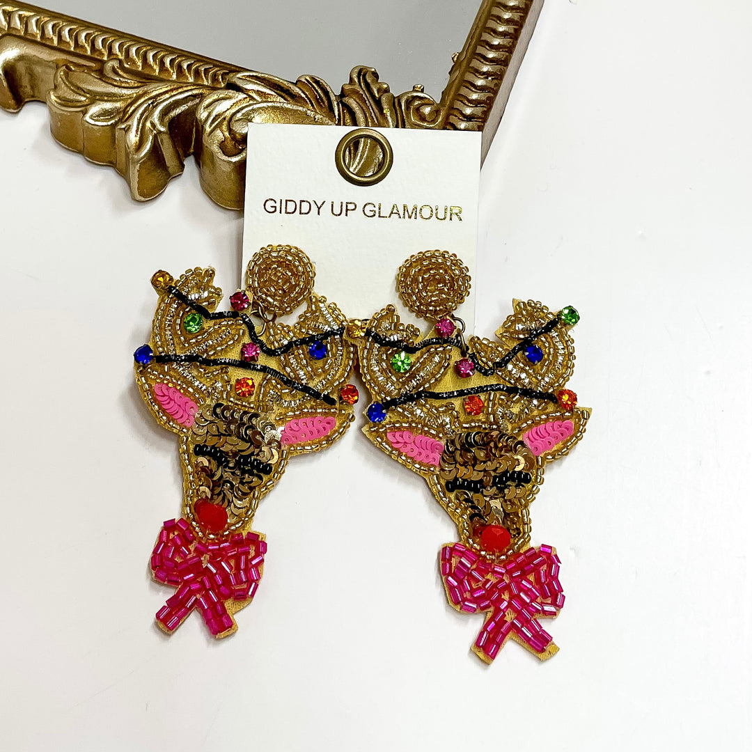 Decorative earrings with pink bows on a 'Giddy Up Glamour' card.