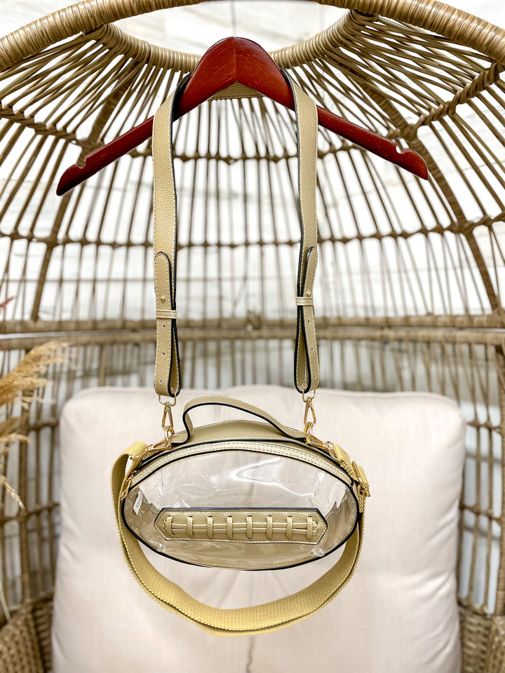 Clear football-shaped stadium bag with faux leather trim and gold hardware from Giddy Up Glamour.