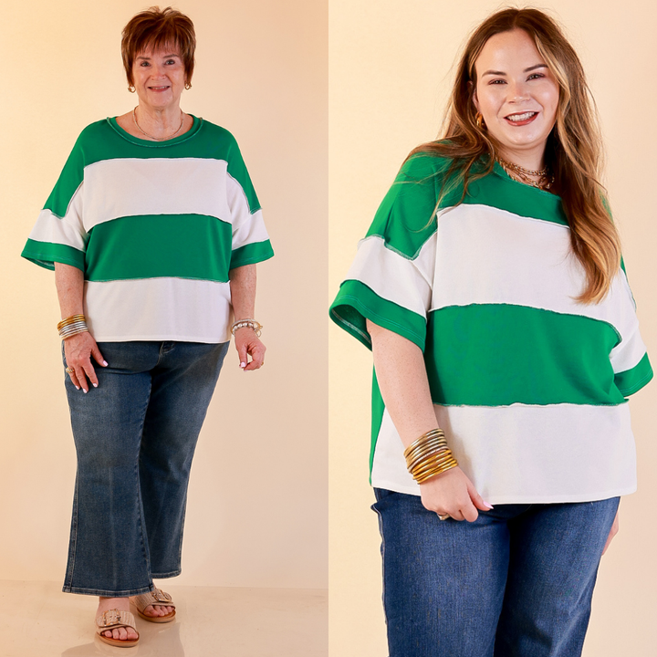 Models are wearing Color Block Rugby Style Wide Stripe Relaxed Short Sleeve Top in Kelly Green with Jeans against a beige backdrop. 