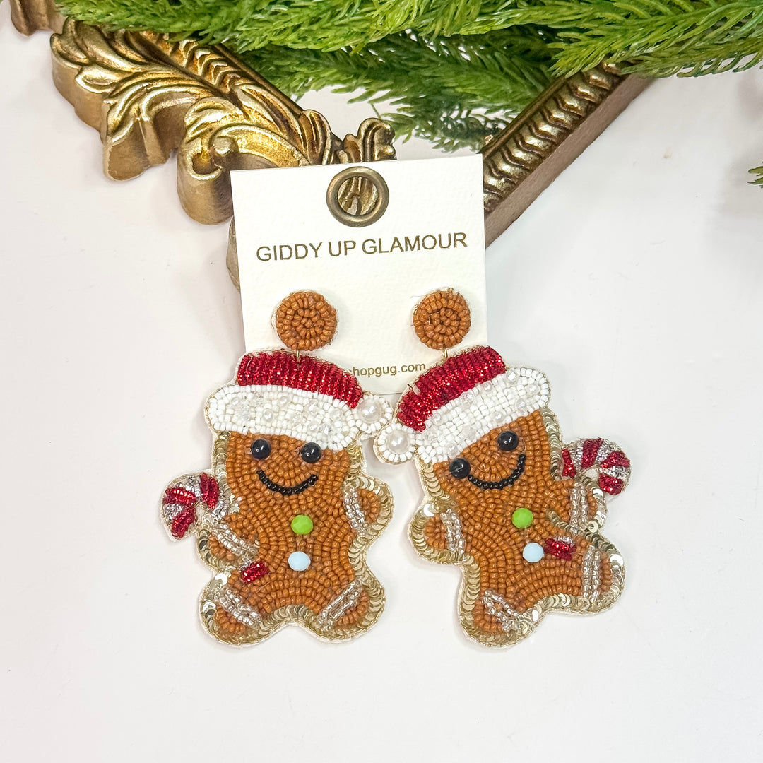 Gingerbread man earrings with red hats on a 'Giddy Up Glamour' card.