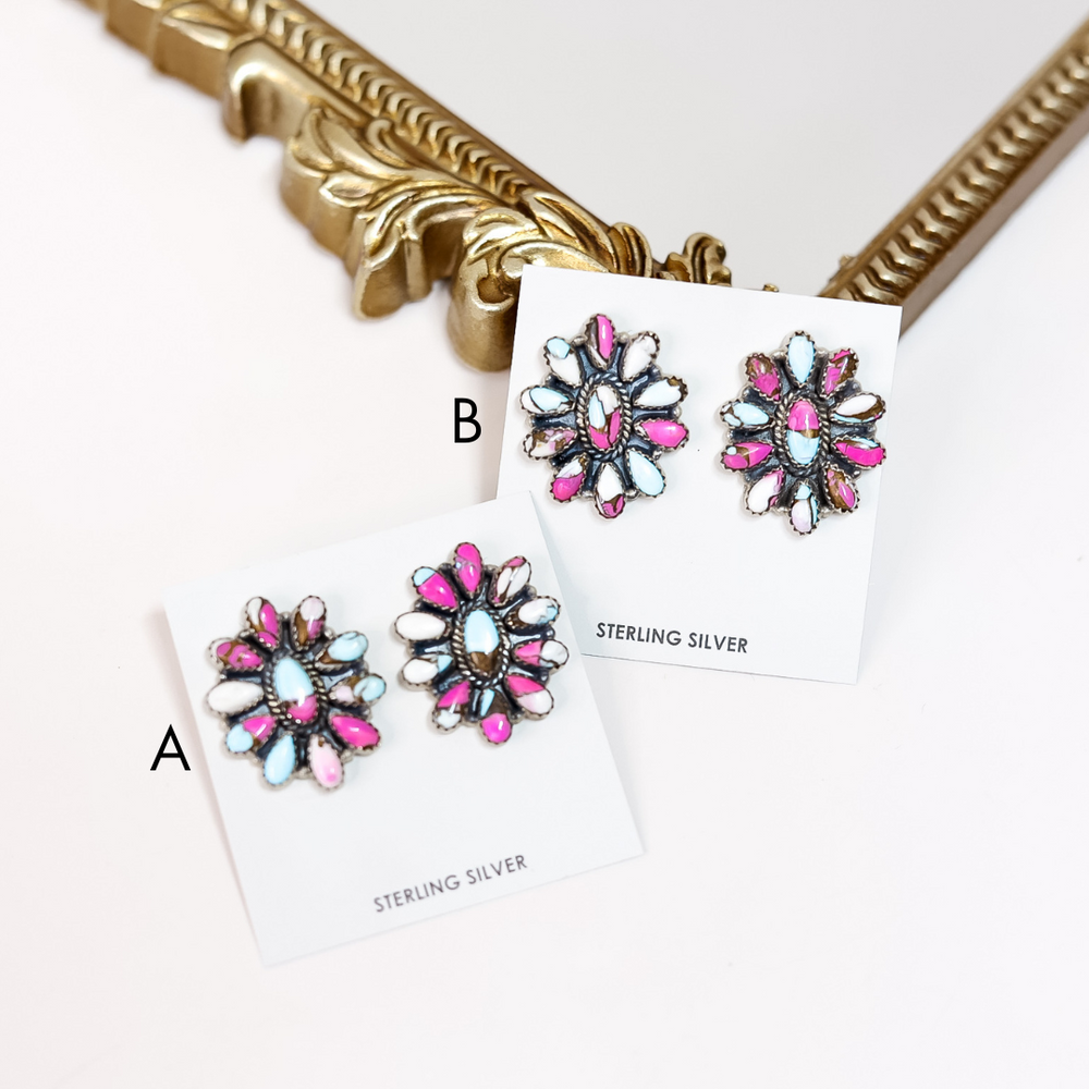 Pair of floral earrings with pink and blue accents on a white card with 'Sterling Silver' text, against a gold frame background.