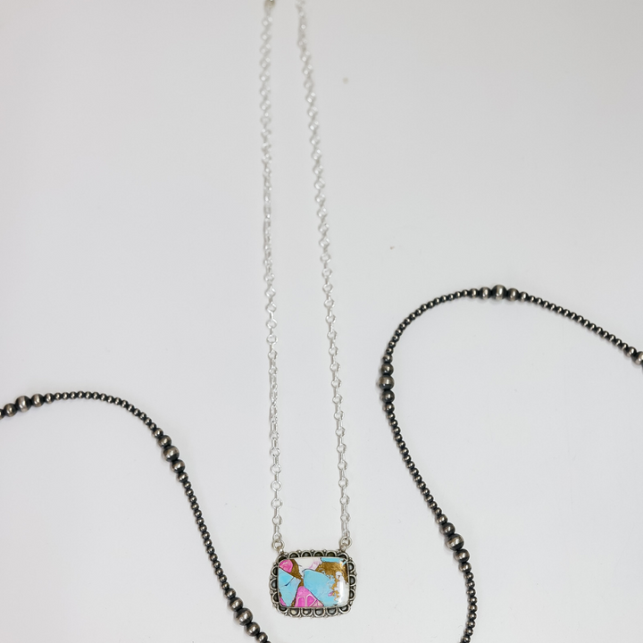 Necklace with a small square pendant featuring colorful characters on a white background