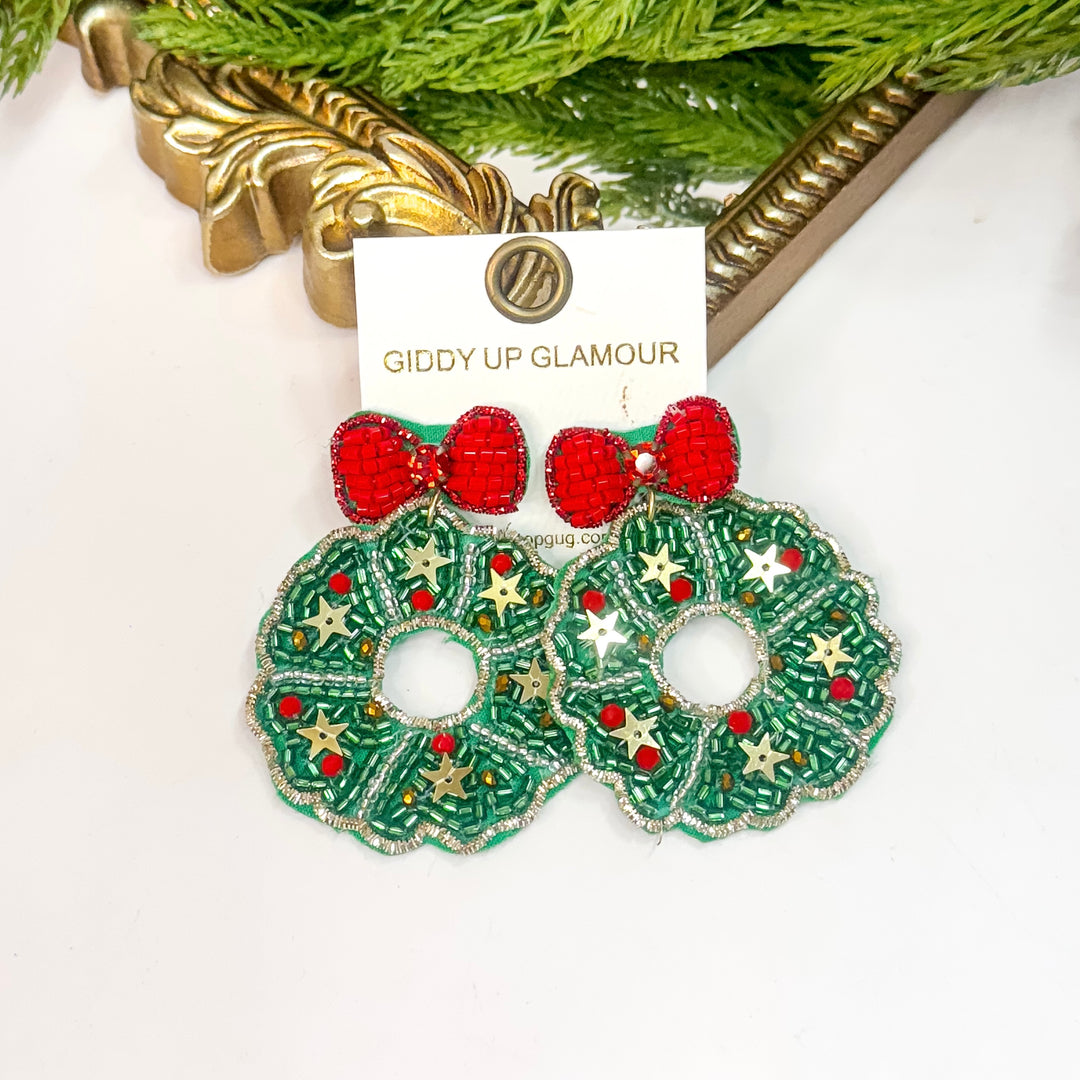 Beaded Christmas wreath earrings with red bow and gold star accents from Giddy Up Glamour