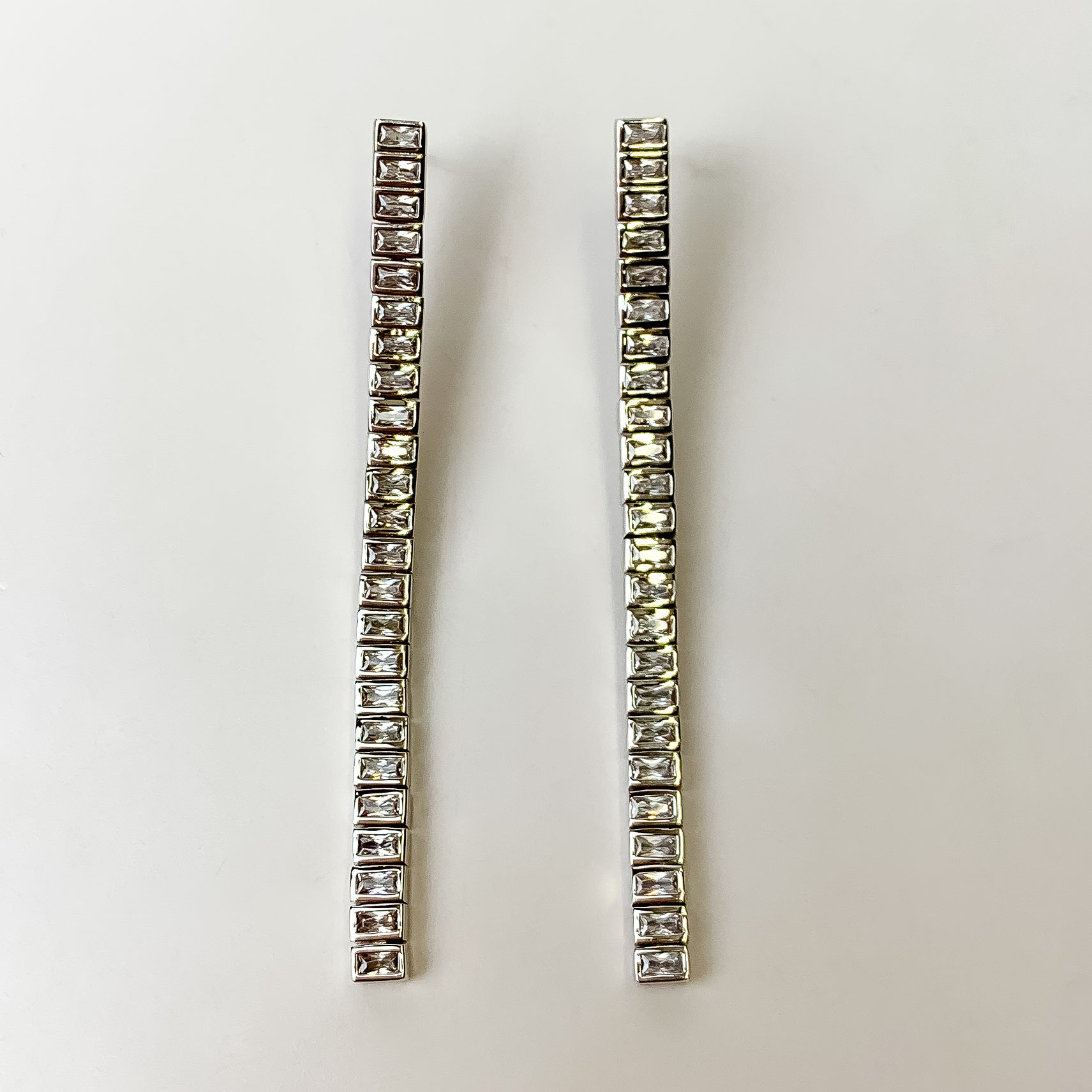 These Gracie long Silver Tennis Linear Earrings in White by Kendra Scott are pictured on a white background.