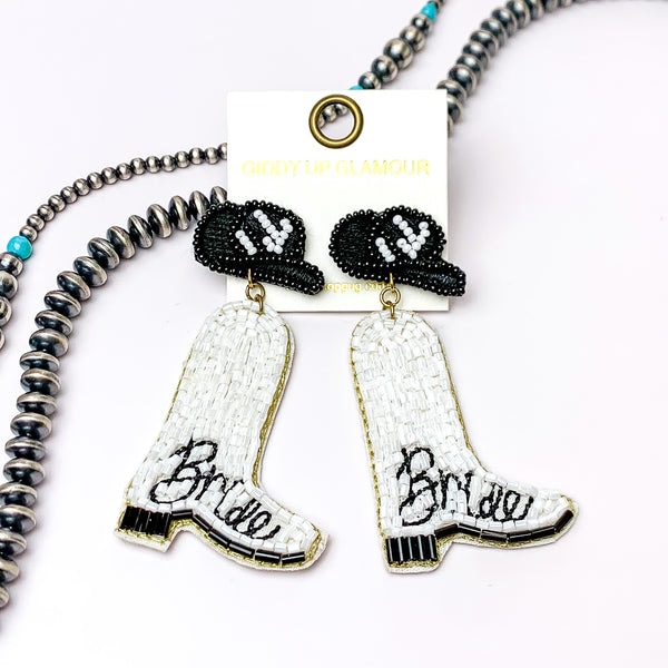 Beaded Bride White Cowboy Boot Earrings with Black Hat Studs. Pictured on a white background with beads through the back.