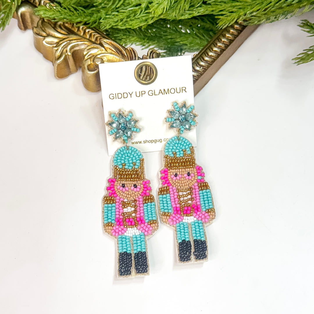 Turquoise and pink beaded nutcracker earrings with blue snowflake tops from Giddy Up Glamour