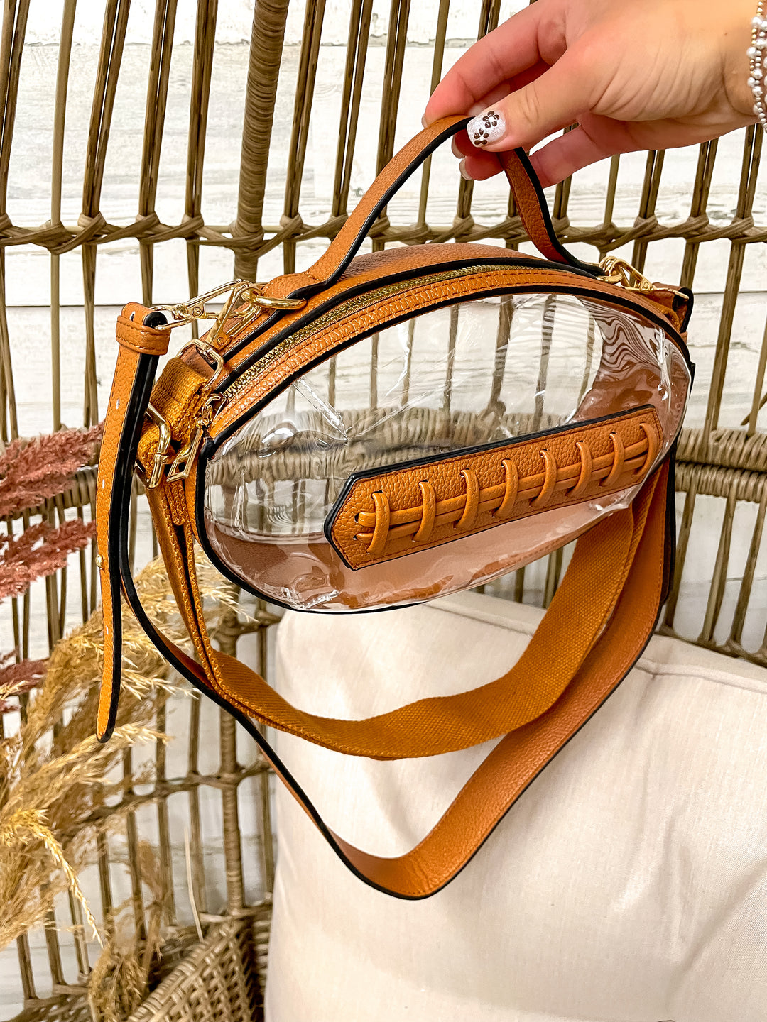 Clear football-shaped stadium bag with faux leather trim and gold hardware from Giddy Up Glamour.