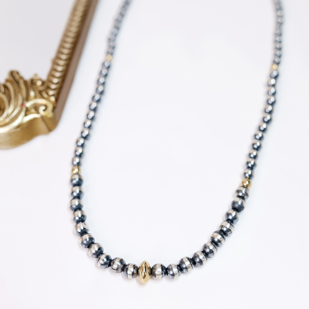 24-inch Navajo pearl necklace with graduated sterling silver beads and 14K gold saucer centerpiece, handcrafted by Native American artisans.