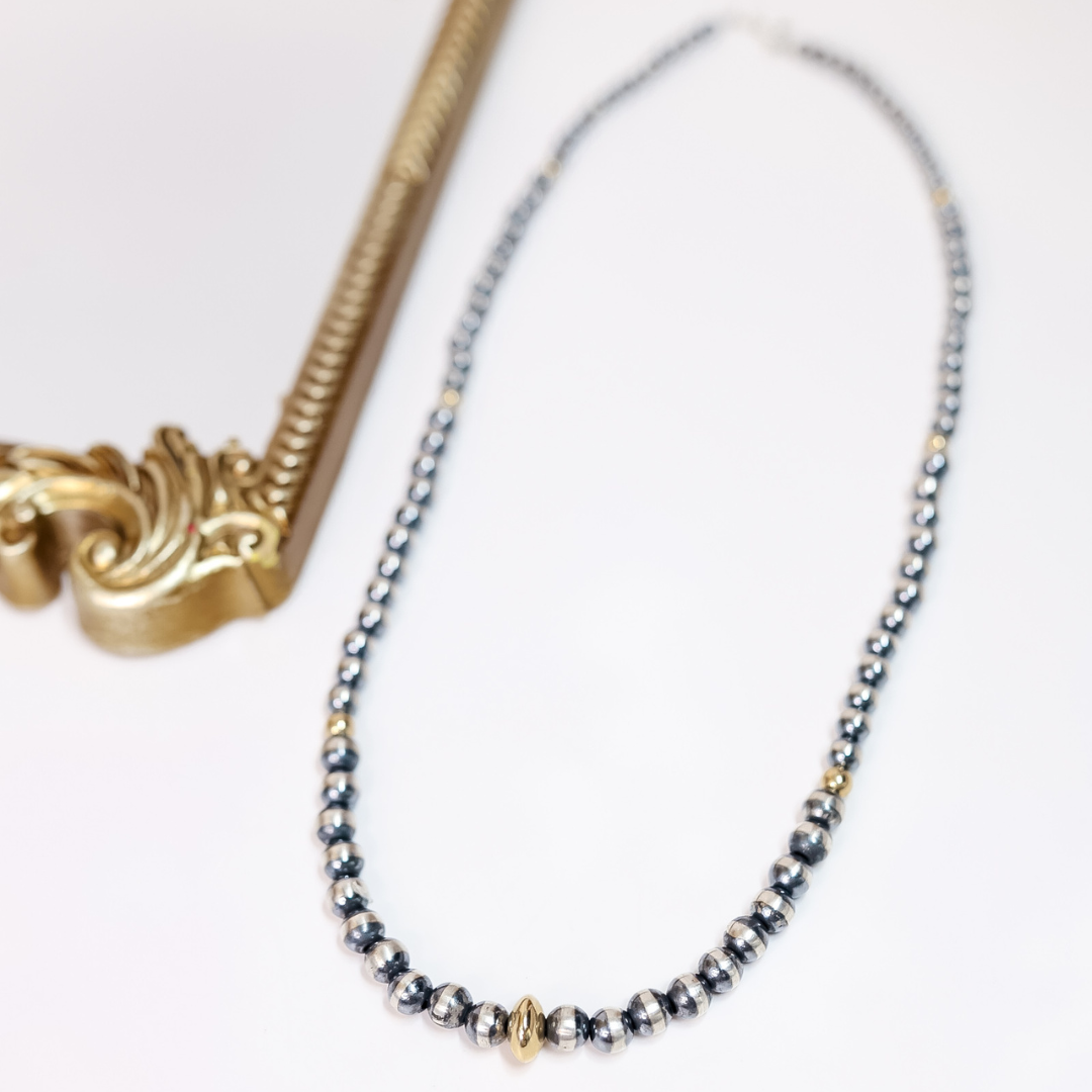 24-inch Navajo pearl necklace with graduated sterling silver beads and 14K gold saucer centerpiece, handcrafted by Native American artisans.