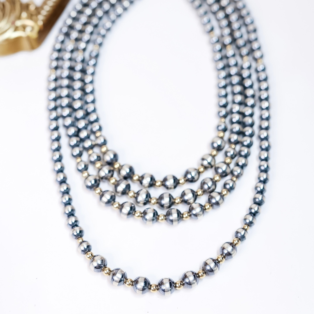 Layered Navajo pearl and gold accent necklaces with 8mm sterling silver beads and 10mm gold-detailed center, available in multiple lengths.