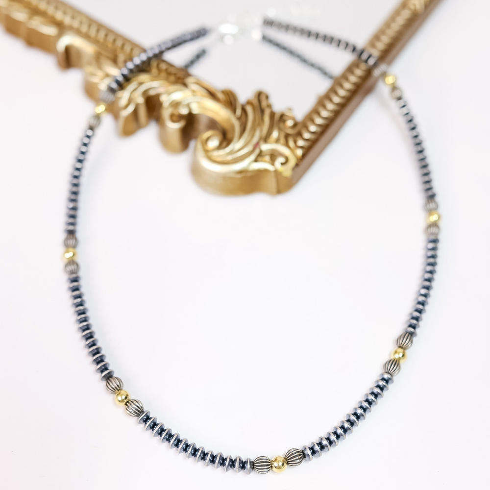Hand-strung Navajo pearl necklace with 7mm saucer beads, ribbed sterling silver accents, and 14K gold-plated beads. 20-inch necklace with 2-inch extender.