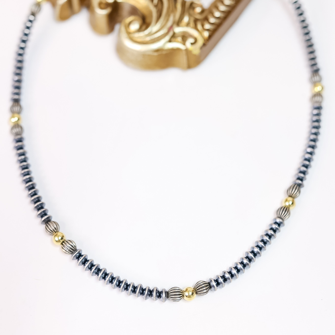 Hand-strung Navajo pearl necklace with 7mm saucer beads, ribbed sterling silver accents, and 14K gold-plated beads. 20-inch necklace with 2-inch extender.