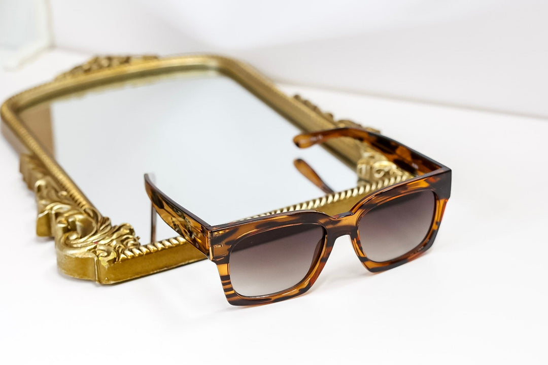Sunglasses with a gold frame on a white background