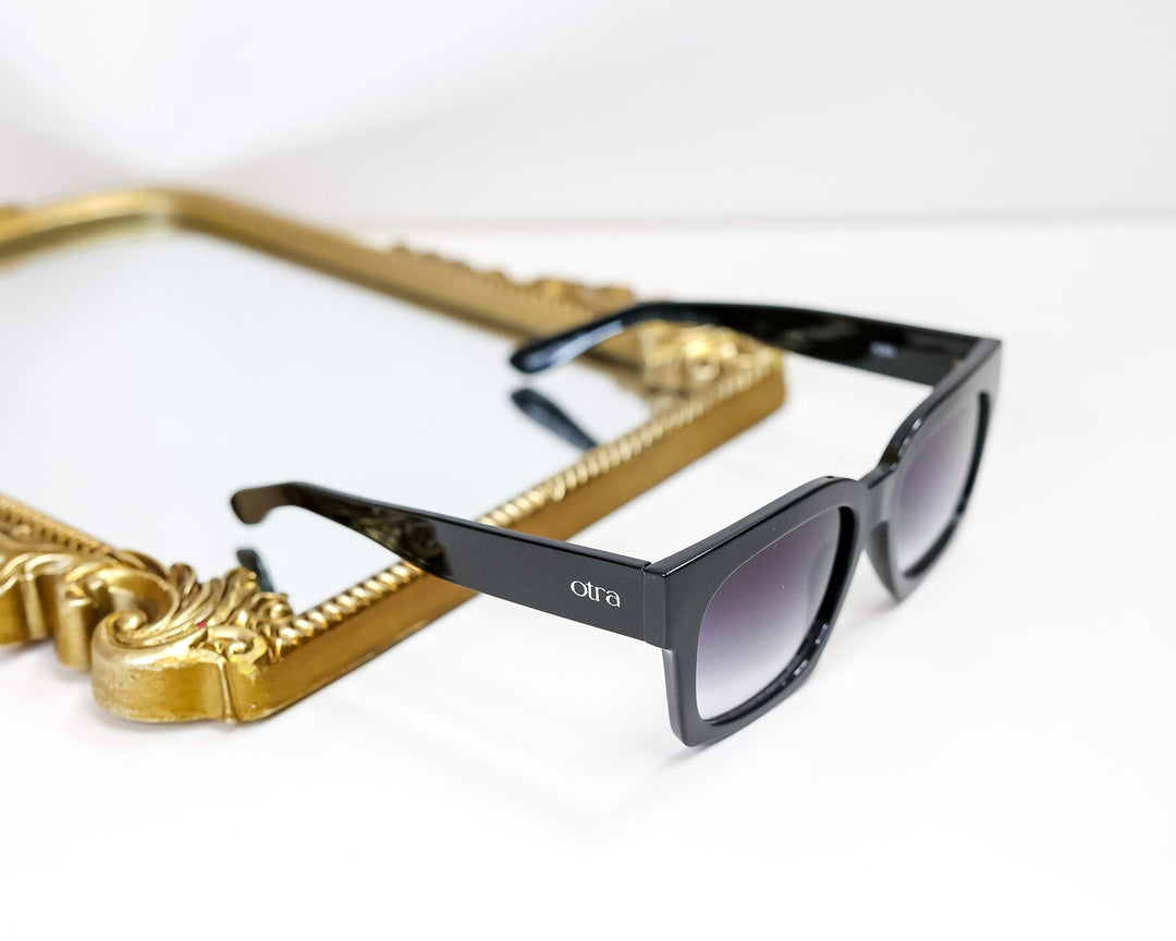 Black sunglasses with gold frame on a white background