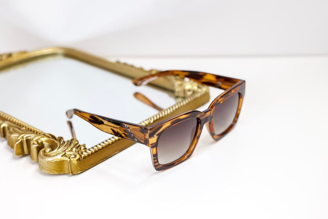 Sunglasses with a gold frame on a white background