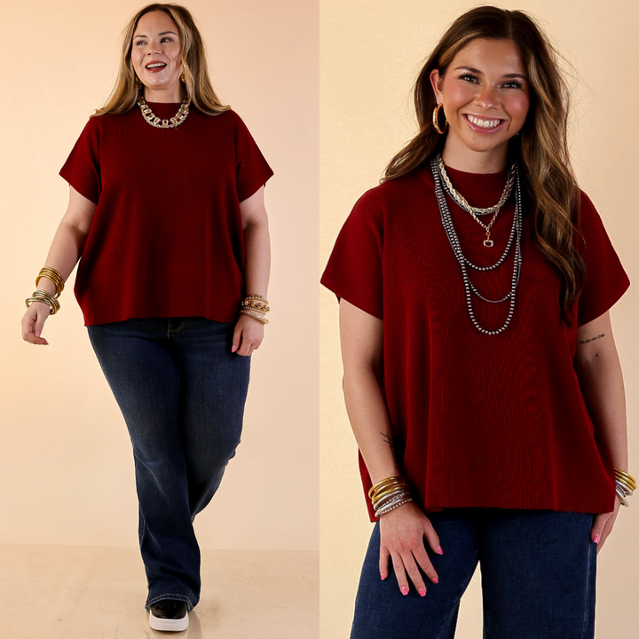 Models are wearing Short Sleeve Mock Neck Top in Maroon with Jeans against a beige backdrop.