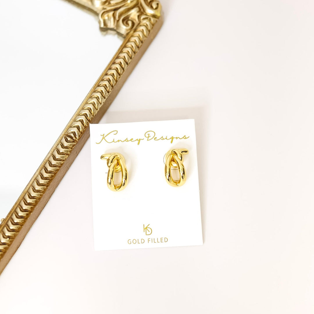 Gold-filled earrings on a kinsey designs branded card with a gold decorative object.