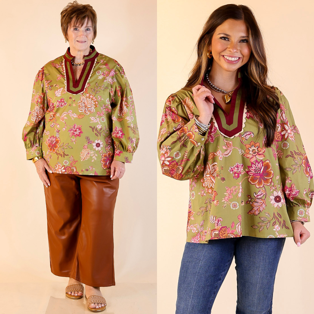 Two women wearing a floral long sleeve  blouse in olive green with a plain background