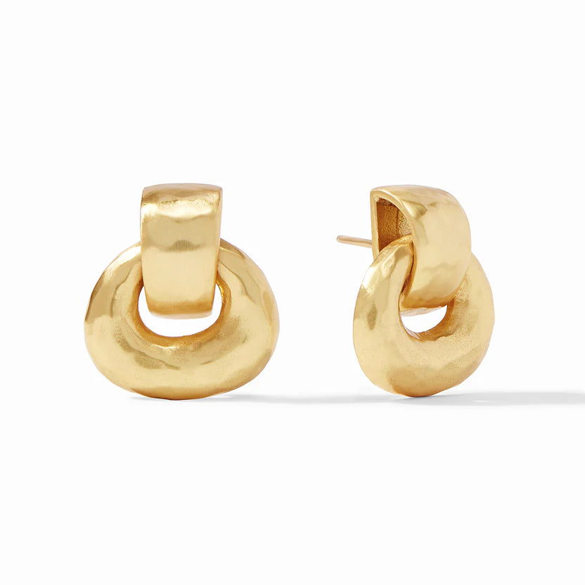 Pictured is a pair of gold, hammered doorknocker earrings on a white background. 