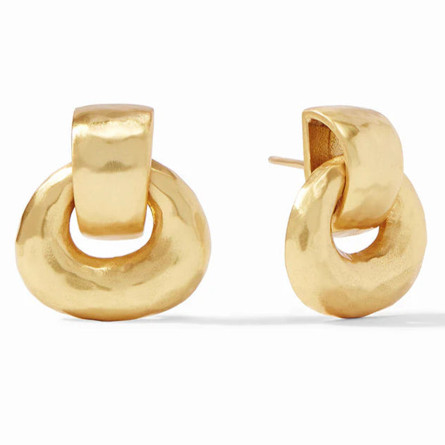 Pictured is a pair of gold, hammered doorknocker earrings on a white background. 