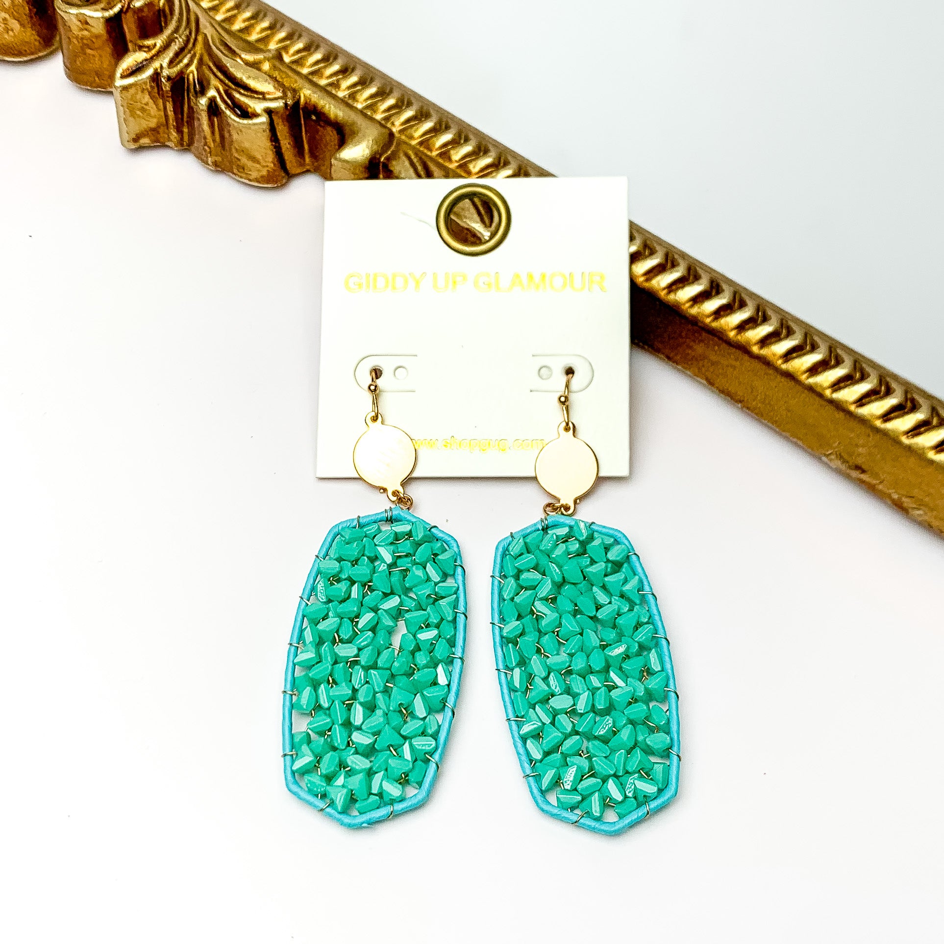 Turquoise Large Drop Earring with Gold Tone Accessory. Pictured on a white background with a gold frame through it.