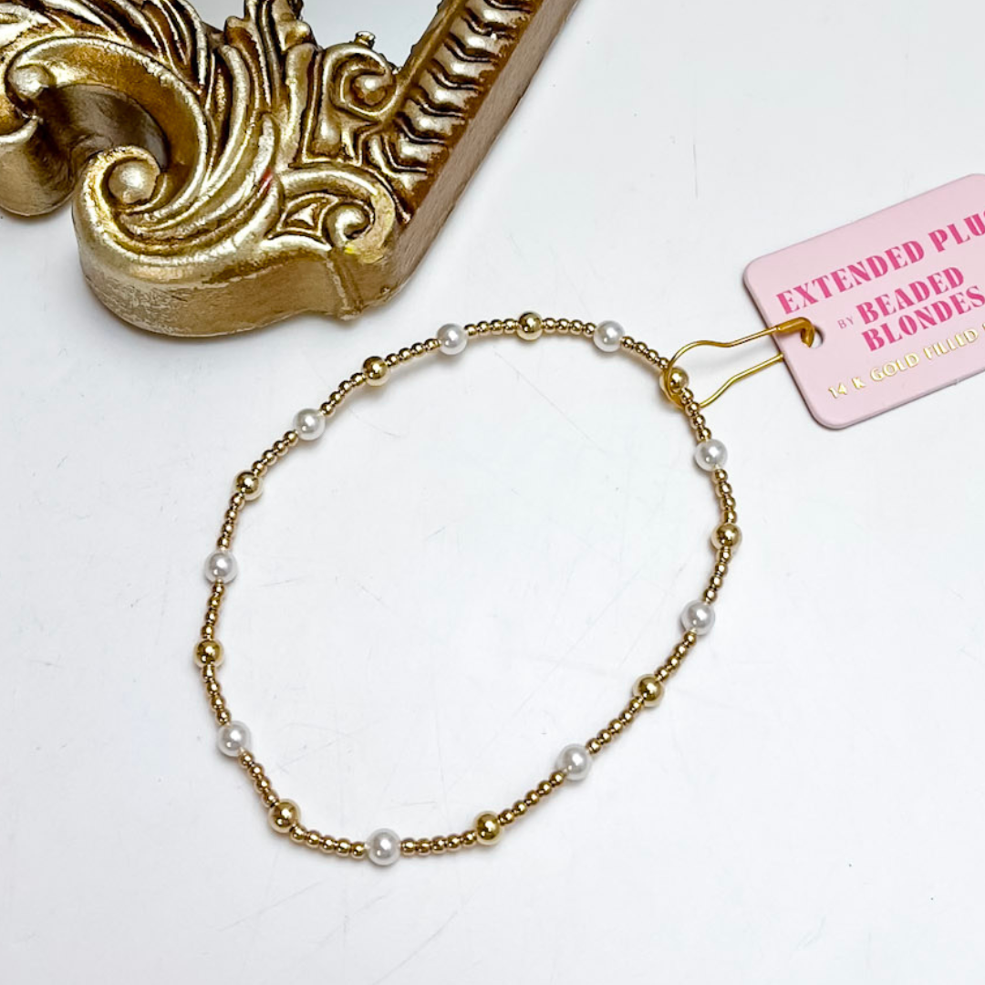 Gold bracelet with pearls on a white background