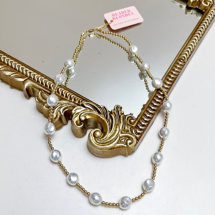 Necklace with pearls and gold chain on a decorative mirror