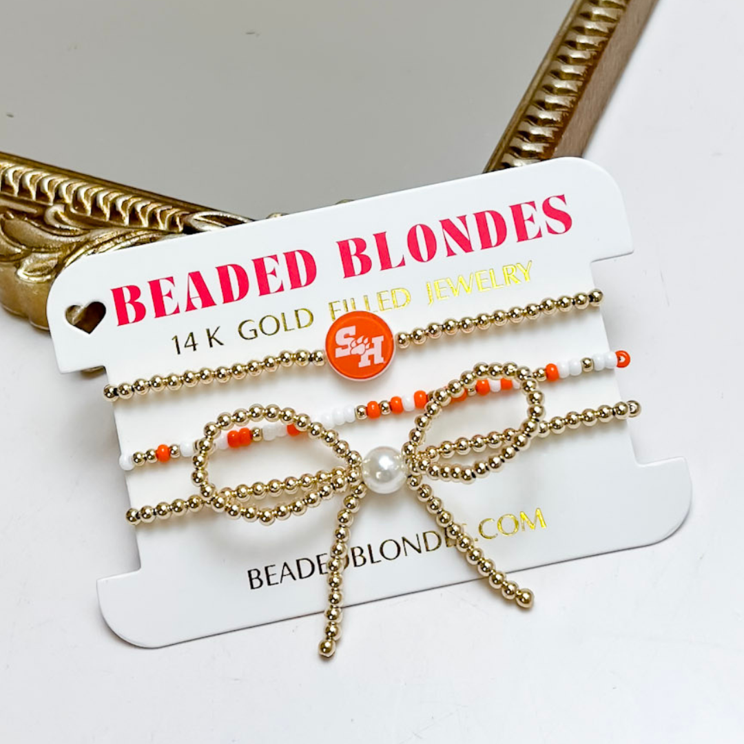 Gold and orange beaded bow-shaped jewelry on a &