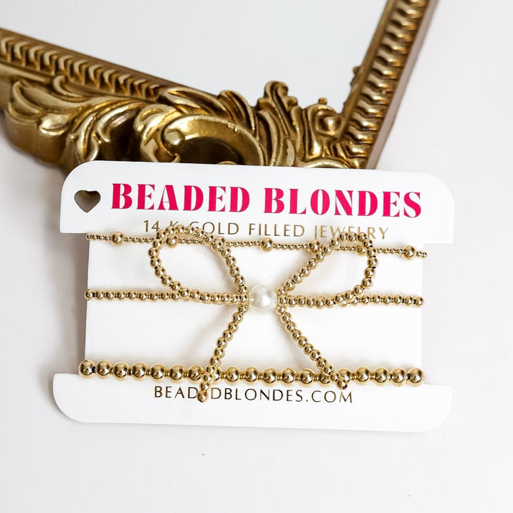white background with gold framed mirror showing three Beaded Blondes bracelet set including a bow with a pearl center as well as a mix size bracelet and a 5mm bracelet all made in United States